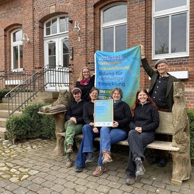 Team Umweltbildung auf Gut Herbigshagen präsentiert Urkunde und Fahne