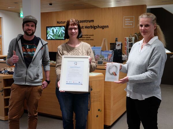 Qualitätssiegel „ServiceQualität Deutschland“ für Gut Herbigshagen Martin Becher vom Besucherservice und Nancy Dietrich, Seminarmanagement Tagungen und Umweltbildung, freuen sich mit Carolin Ruh über die Auszeichnung